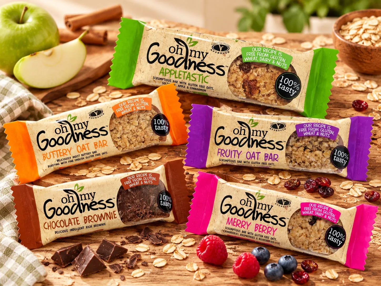 Oh My Goodness gluten free oat bars: Appletastic, Buttery Oat Bar, Fruity Oat Bar, Chocolate Brownie and Merry Berry, with apple, oats, chocolate and berries.